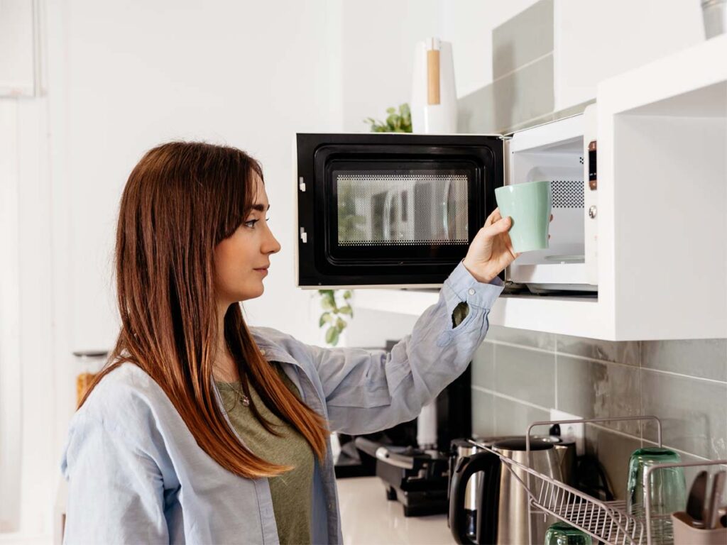 Girl Using Microwave to Heat Cup