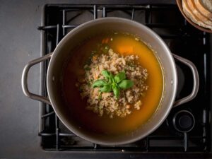 Quinoa cooking in pot with vegetable broth