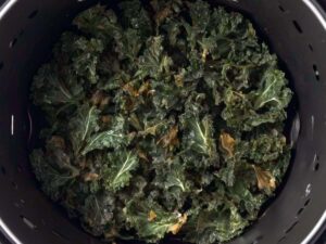 Crispy kale chips in an open air fryer after cooking