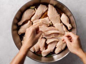 Chicken breast strips being added to marinade