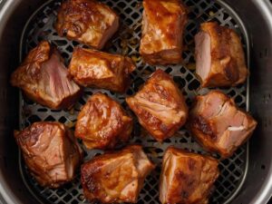 Arranging pork chunks in an air fryer basket