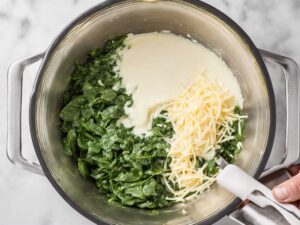 Adding spinach and cheese to egg mixture