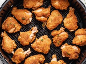 Placing coated chicken pieces in the air fryer basket