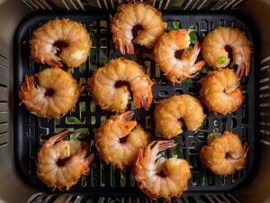 Coconut shrimp arranged in air fryer basket